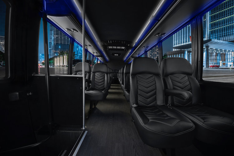 Photograph of the interior of an executive shuttle bus with black seats.